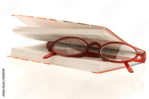 Foto: red reading glasses between a almost closed book red reading glasses between a almost closed book