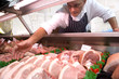 Butcher reaching for chops, low angle view