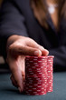 Woman with hand on pile of gambling chips, close-up of hand