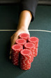 Woman pushing gambling chips onto table, close-up of hand