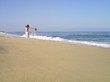 Woman on beach with arms outstretched, looking up