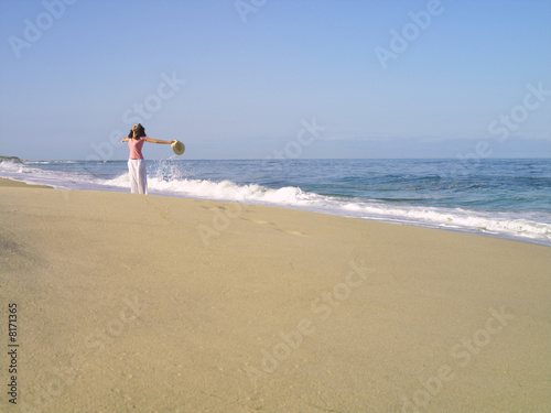 Photo: Woman on beach with arms outstretched, looking up Woman on beach with arms outstretched, looking up