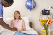 Doctor with girl (10-12) in hospital bed