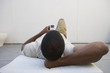 Man on lounge chair with MP3 player, rear view