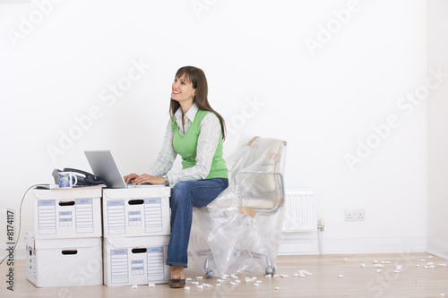 Photo: Woman working amidst boxes Woman working amidst boxes