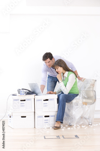 Photo: Man and woman working amidst boxes Man and woman working amidst boxes