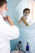 Young man shaving in mirror