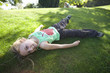 Girl (8-10) laying on grass, portrait