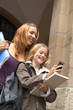 Two young females looking at a mobile phone.