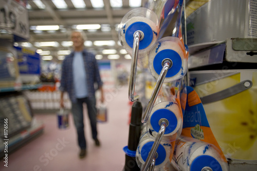 Photo: Man in hardware store, close-up of paint rollers Man in hardware store, close-up of paint rollers
