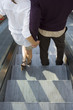 A couple holding hands on the escalator.