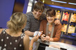 A couple buying movie tickets at the box office.