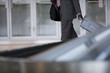 Businessman removing suitcase from luggage carousel in baggage claim