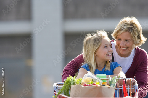Foto: Mother and daughter pushing grocery cart full of groceries Mother and daughter pushing grocery cart full of groceries