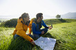A couple using a map and a compass to find directions.