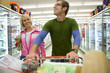 Couple grocery shopping in frozen foods section