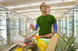 Man grocery shopping in frozen foods section