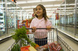 Young girl grocery shopping in frozen foods section