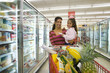 Mother and daughter grocery shopping in frozen foods section