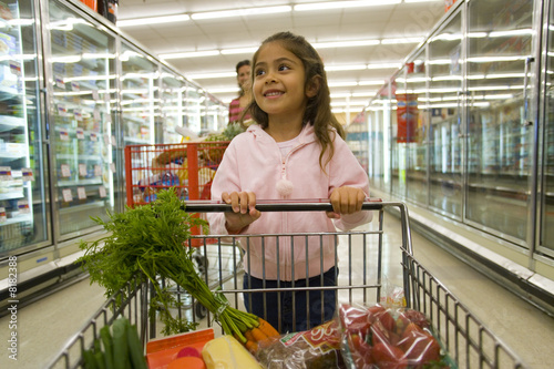 Photo: Young girl grocery shopping in frozen foods section Young girl grocery shopping in frozen foods section