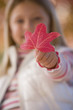 Close up of young girl holding autumn leaf