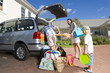 Foto: Family of three loading car with luggage, low angle view Family of three loading car with luggage, low angle view