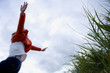 Girl (7-9 years) jumping from grass outdoors, low angle view