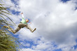 Boy (7-9 years) jumping from grass outdoors, low angle view
