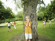 Photo: Boy (7-9) with hands covering eyes playing hide and seek in park, hiding from friends behind tree Boy (7-9) with hands covering eyes playing hide and seek in park, hiding from friends behind tree