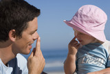 Photo: Father playing with daughter (2-3), touching noses with fingers, smiling, close-up, side view Father playing with daughter (2-3), touching noses with fingers, smiling, close-up, side view