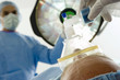 Photo: Surgeons operating on patient, positioning oxygen mask over mouth, rear view, low angle view Surgeons operating on patient, positioning oxygen mask over mouth, rear view, low angle view