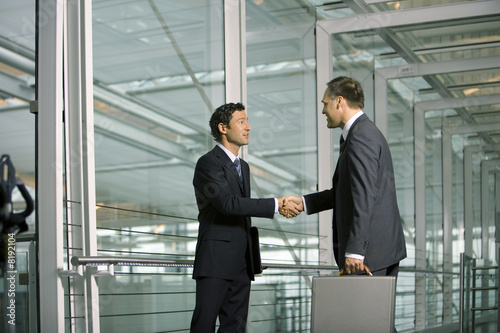Foto: Two businessmen shake hands. Two businessmen shake hands.