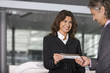 A businessman showing his boarding pass at the check in counter.