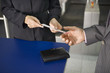 A businessman showing his boarding pass at the check in counter.