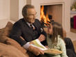 Man reading a storybook for his granddaughter.