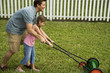 father and daughter mowing the lawn together\n