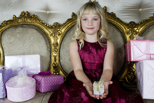 Photo: Little girl holding out a birthday present Little girl holding out a birthday present