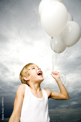 Photo: A young boy with a bunch of balloons A young boy with a bunch of balloons