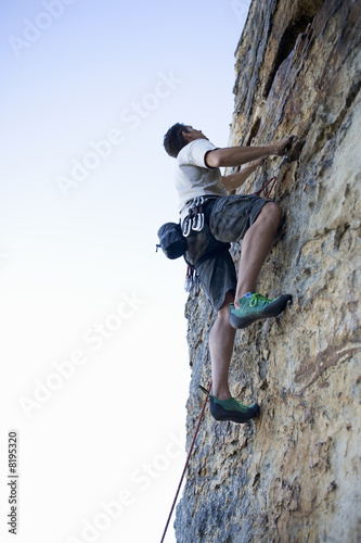 Photo: A climber climbing a rock face A climber climbing a rock face