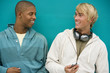 Two young men leaning against a green painted wall