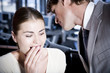 Two business colleagues whispering to each other