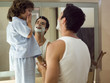 Boy watching his father shave.