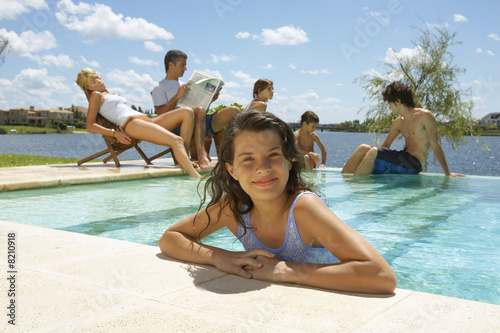 Foto: A girl in the pool, family in the background. A girl in the pool, family in the background.