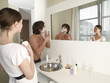 Woman looking at her boyfriend shaving.
