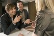 Two businessmen talking to a receptionist