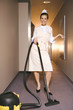 Portrait of a maid cleaning the floor with a vacuum cleaner