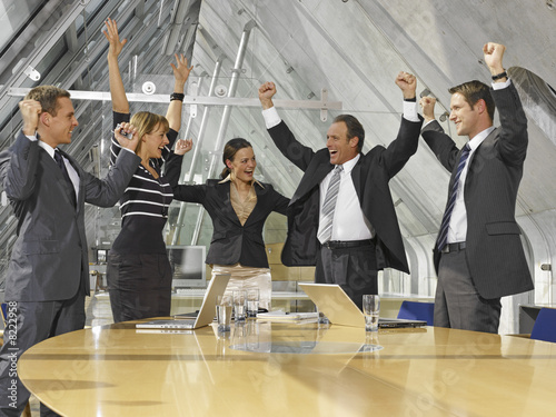 Foto: Five business executives cheering in a board room Five business executives cheering in a board room