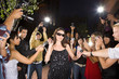 Paparazzi taking photographs of young woman in sunglasses, low angle view