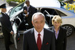 Photo: Businessman and colleagues getting out of car, chauffeur holding door open, portrait Businessman and colleagues getting out of car, chauffeur holding door open, portrait