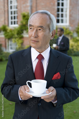 Foto: Mature businessman with teacup outdoors Mature businessman with teacup outdoors